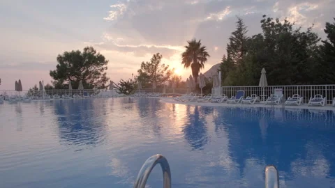 Sunset Over a Poolside with Lounge Chairs Stock Footage 282931744