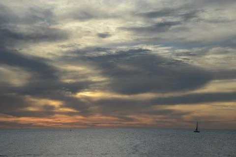 Sunset over Punta del Este bay with a sailboat on tranquil waters Stock Photos