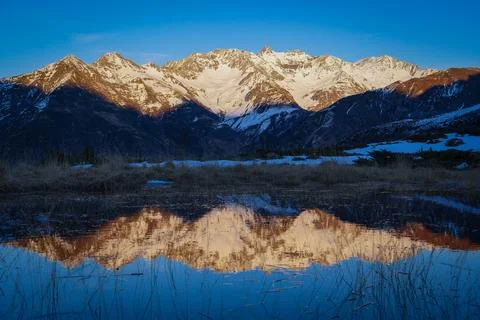 Sunset over the Pyrenees mountains with the reflection of the peaks in the water Stock-Fotos
