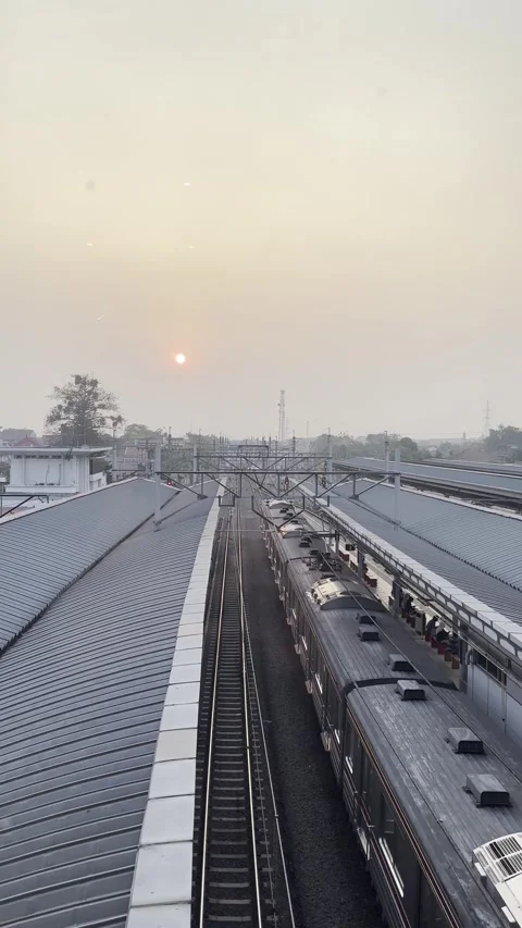 Sunset Over Railway Station With Commuter Train and Parallel Tracks Vertical Vid Stock Footage 340943007