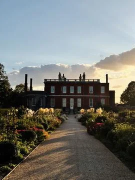 Sunset over a red brick mansion Ranger's House with formal garden and grave.. Fotos Stock