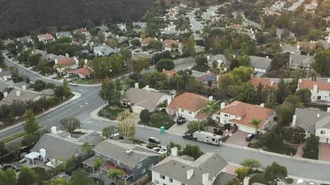 The Sunset over a residential area in between green mountiains in Southern Stock Footage 98188117