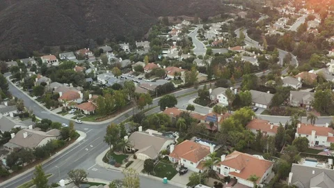 The Sunset over a residential area in between green mountiains in Southern Stock Footage 98188970