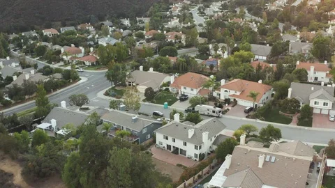 The Sunset over a residential area in between green mountiains in Southern Stock Footage 98222610