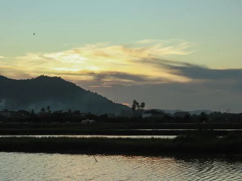 Sunset over rice fields and mountains in the background, Indonesia Stock Photos