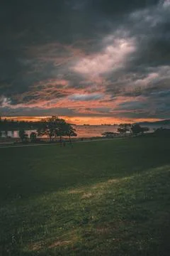 Sunset over the river with dark clouds Stock Photos