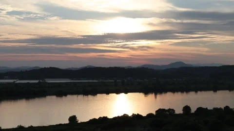 Sunset over river with green field, drone shot Stock Footage 303539848