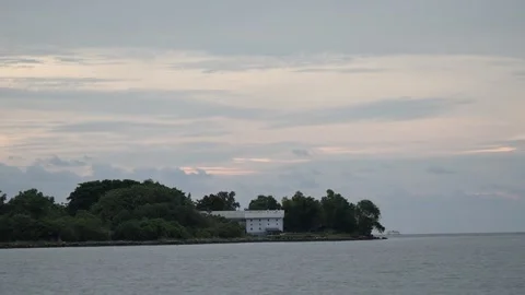 Sunset over the river with an island in the middle of sea Stock Footage 258321175