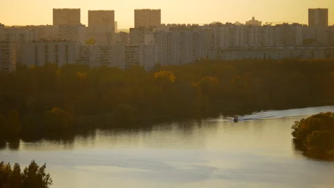 Sunset over the river. A motor boat moves along the river in the sunset light.  Video stock 163374606