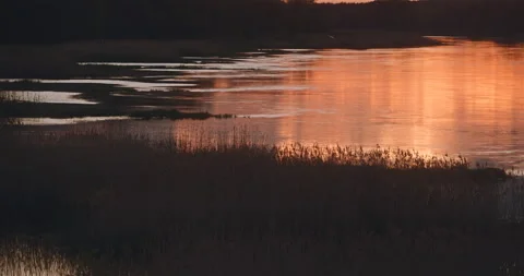 Sunset over the river reflecting the sky Stock Footage 242787623