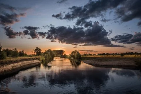 Sunset over the river. The setting sun and heavy clouds. 写真素材