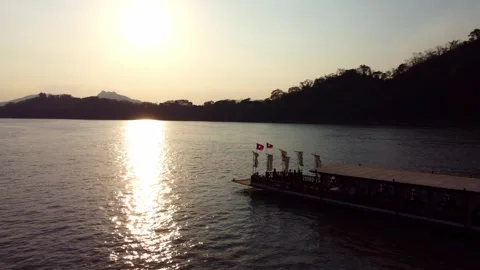 Sunset over river with traditional boat and mountains in the background 스톡 동영상 344449273