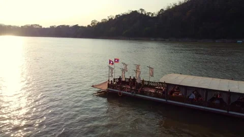 Sunset over river with traditional boat and mountains in the background Video stock 344449427