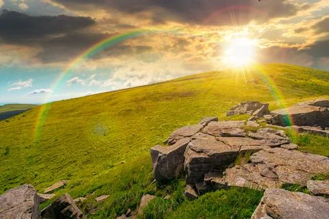 Sunset over rocks and rolling hills in mountain landscape in summer Stock Photos