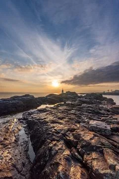 Sunset over rocky coastline with dramatic sky vertical frame Stock Photos