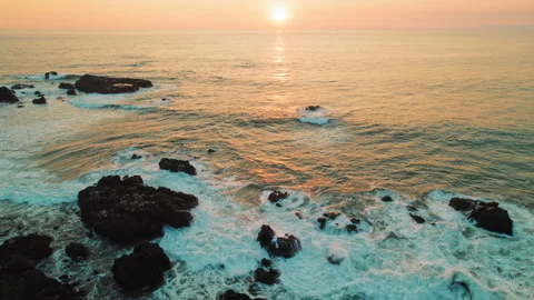 Sunset over rocky coastline with ocean waves crashing in Jaco Costa Rica Stock Footage 344760392