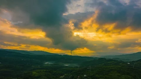 Sunset Over Rolling Green Hills with Sunbeams And Industrial Smoke Stack 動画素材 342093292