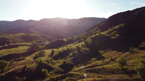 Sunset over rolling hills with lush greenery and long shadows Stock Footage 258511685
