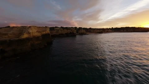 Sunset over rugged coastline with calm waters and dramatic sky Video stock 346091858