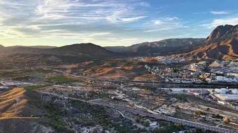 Sunset Over Rugged Mountain Slopes And Town, Dramatic Sunset Illuminating Rocky Stock Photos