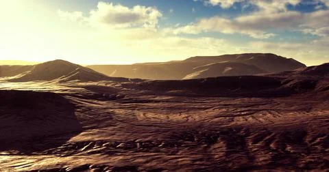 Sunset over rugged terrain with distant mountains and dynamic clouds 库存插图