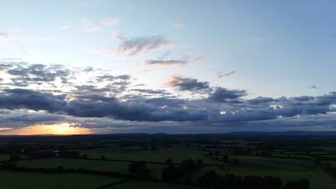 Sunset Over Rural Fields with Dramatic Cloudy Sky Aerial View Stockfoto's