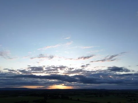 Sunset Over Rural Fields with Dramatic Cloudy Sky Aerial View Stockfoto's