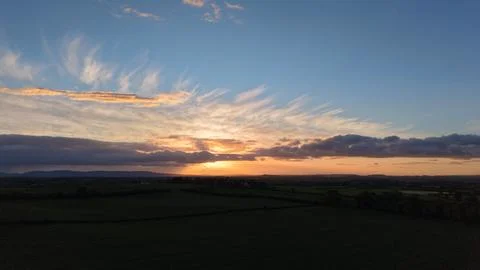 Sunset Over Rural Fields With Dramatic Clouds and Blue Sky Stock Photos