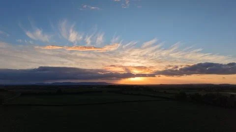 Sunset Over Rural Fields With Dramatic Clouds and Blue Sky Stock Photos