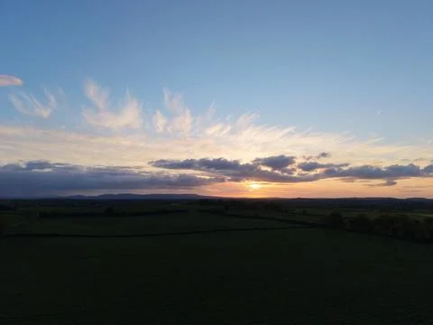 Sunset Over Rural Fields With Dramatic Clouds and Blue Sky Stock Photos