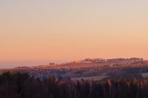Sunset over rural landscape with village - in the foreground forest, on the h Stock Photos
