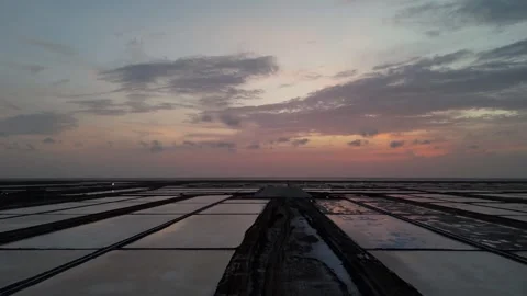 Sunset Over Salt Pans with Reflective Water and Dramatic Evening Sky Aerial Stock-Footage 337959540