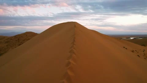 Sunset over the sand dunes in the desert. Aerial view. Golden sand close up Stock Footage 233518344