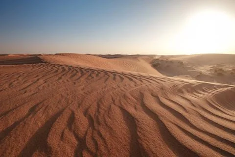 Sunset over the sand dunes in the desert. Stock Photos