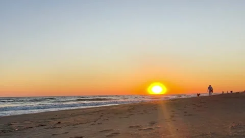 Sunset Over Sandy Beach and Calm Sea Waves on a Peaceful Evening 動画素材 343490409