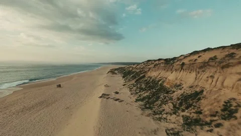 Sunset over sandy beach with dunes and gentle ocean waves Stock Footage 340227153