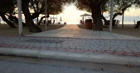 Sunset over a sandy beach with lounges and the sea Stock Footage 107930863