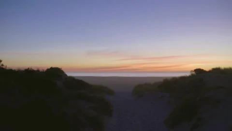 Sunset over sandy beach pathway reveal cinematic Stock Footage 151349620