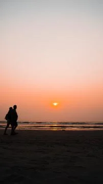 Sunset over sea and beach. Cloudless sundown sky over waving sea and sandy beach Stock Photos