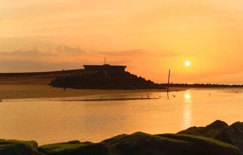 Sunset over sea bay. Dramatic lighting, sunlight rays and beautiful reflation Stock Photos