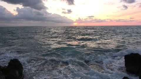 Sunset over the sea, in a cliff in Cefal, Italy. The sun and a ship with a cl Stock Footage 154084994