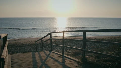 Sunset over the sea, deserted beach and old wooden bridge to the beach Stock Footage 314015736