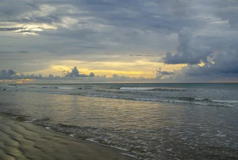 Sunset over the sea with dramatic cloud contrast and shimmering highlights .. Stock Photos