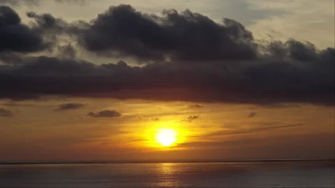 Sunset over the sea with a large dark cloud over it Stock Footage 264944826