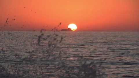 Sunset over the Sea with a Large Ship  Against the Sun and Waves Breaking- 1829 Stock Footage 314891942