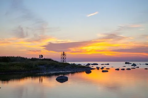 Sunset over sea with magic installation of black monk on the tower Stock Photos