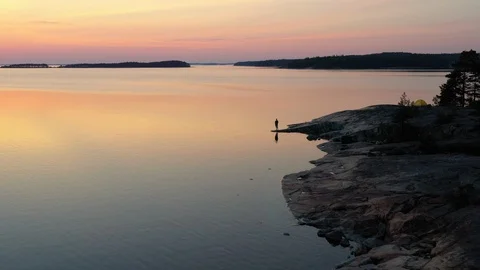 Sunset over the sea with a man walking on the shore Video stock 124393803