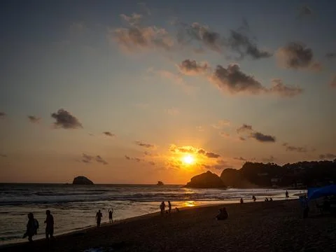 Sunset over the sea with mountains in the background Stock Photos