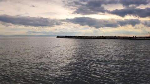 Sunset over Sea Pier and Dramatic Clouds Beautiful Coastal Landscape Background Stock Footage 336340048