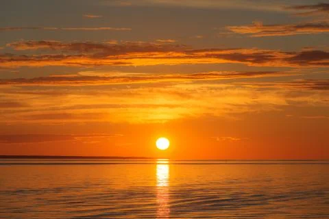 Sunset over sea, red colors, long clouds Stock Photos